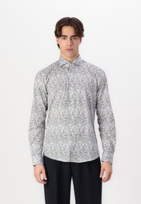 Langermet skjorte med hvit bakgrunn, prydet med et blomstermønster i blått og grått. Med krage som kan knappes ned og figursydd design. Laget av bomull.