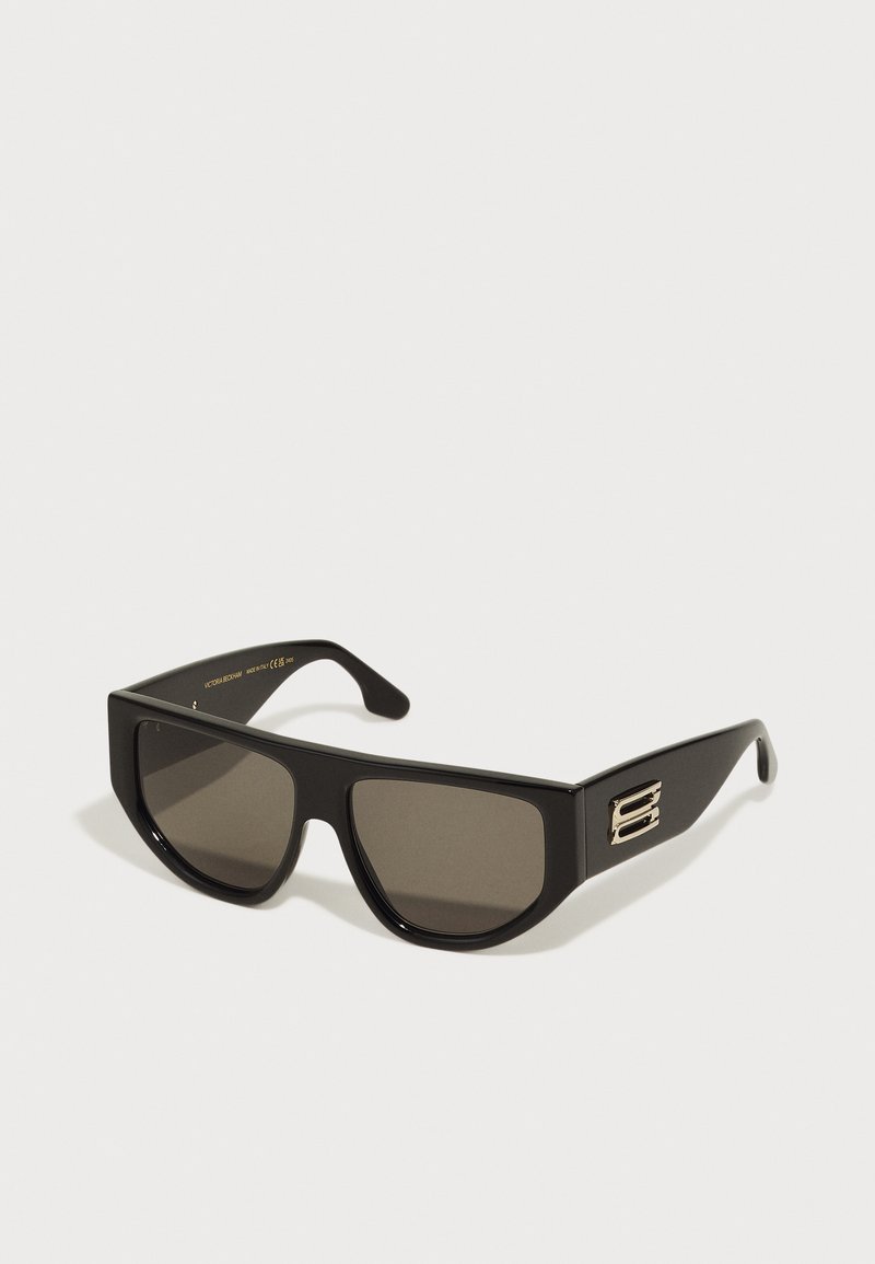 Óculos de sol pretos com uma armação retangular ousada. Apresenta lentes escuras e um detalhe em metal dourado nas hastes. Acabamento em plástico liso.