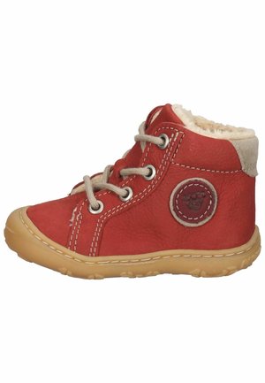 Bottine en cuir rouge avec doublure en fausse fourrure beige, surpiqûres blanches contrastantes, patch logo rond et semelle en caoutchouc souple.