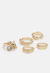 Conjunto de cinco anéis em ouro com diversos designs: uma cabeça de raposa com gemas, um aro liso, um anel com contas, um aro ondulado e um aro retangular.