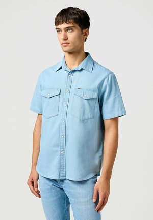 Lichtblauwe, kortärmige, knoopsluiting overhemd van denimstof met twee voorzakken, voorzien van een klein merklogo en een klassieke kraag.