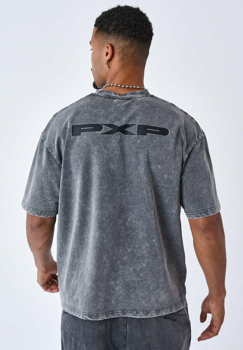 Grijze oversized t-shirt met een vervaagde, gestructureerde afwerking. Heeft een bold zwart "PXP" logo op de achterkant en korte mouwen met een onafgewerkt zoom.