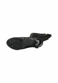 Bottines noires à talons avec tige en dentelle texturée, bout pointu et semelle à motif floral. Étiquette de taille 37 visible.