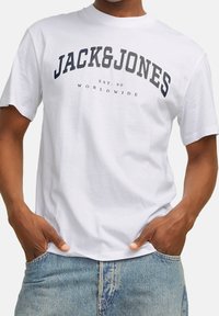 White cotton t-shirt featuring "JACK&JONES" and "EST.90 WORLDWIDE" printed in dark navy. Short sleeves and a crew neck design.