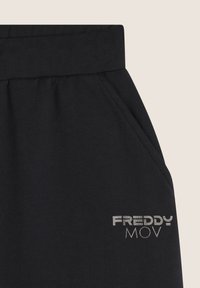 Jogging noirs avec une texture lisse, dotés d'une large ceinture élastique, de poches latérales et d'un logo "FREDDY MOV" brodé en argent.