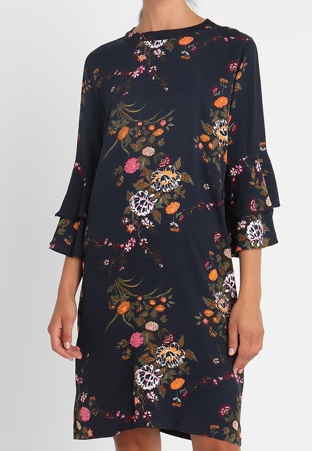 Robe bleu marine longueur genou avec manches longues à volants et motif floral coloré dans des tons orange, rose et blanc.