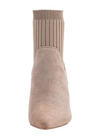 Stivale alla caviglia beige in suede con punta affusolata, polsino a costine in maglia elasticizzata e tacco a blocco, vista frontale su sfondo bianco.