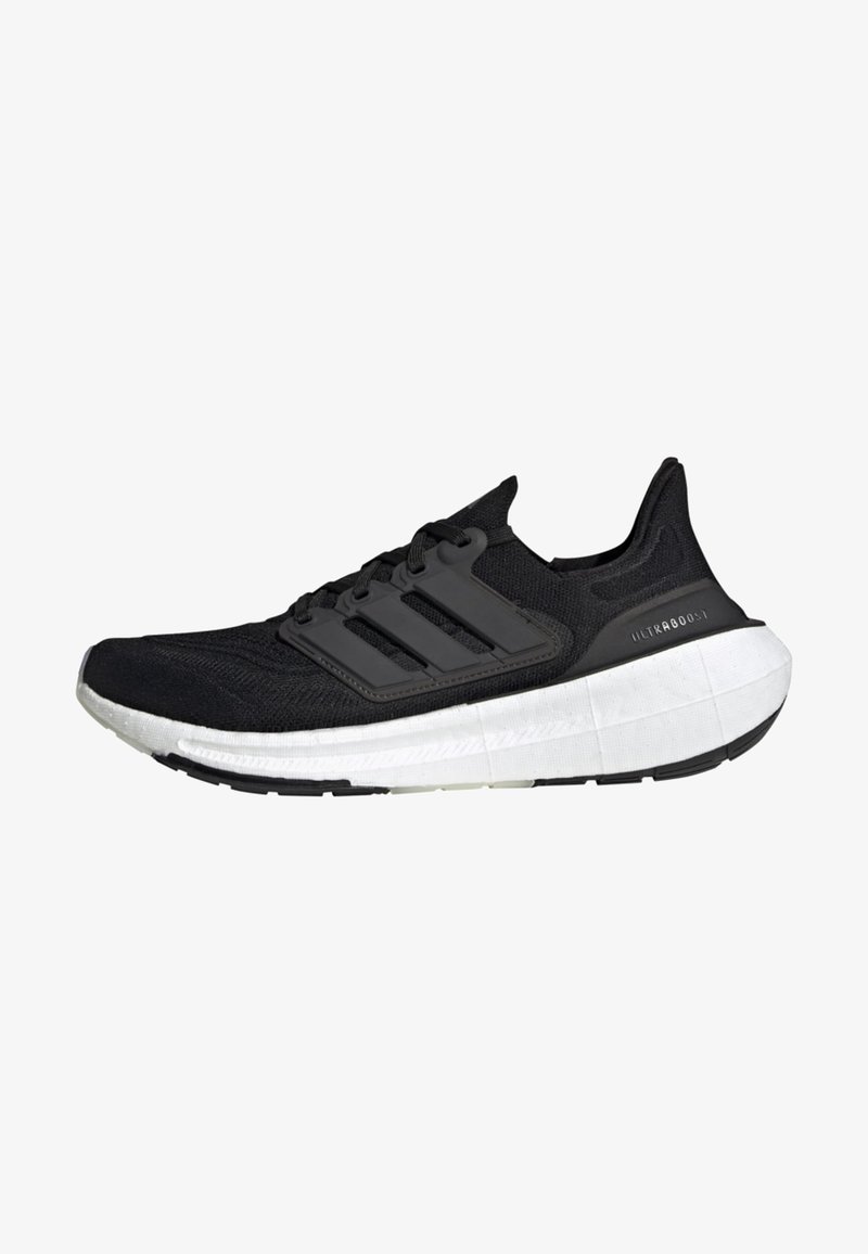 Chaussure de running Adidas Ultraboost noire avec semelle blanche amortie et trois bandes noires sur le côté, vue de profil gauche.