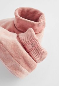 Vaaleanpunainen neule, jossa on korkea ribbireuna. Pehmeä fleece-materiaali, jossa on pieni kangastunnus, jossa on tähti-yksityiskohta hihassa.