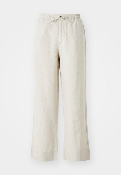 Calças de linho numa cor bege clara, com um corte solto, cintura elástica com cordão e bolsos laterais para maior comodidade.