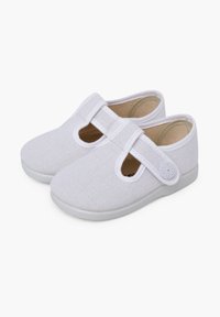 Pantofi albi din pânză cu sistem de prindere Velcro, bot rotund, textură respirabilă și talpă din cauciuc. Include detalii decupate pe laterale.