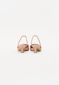 Sandales à talons roses avec un design épuré, des lanières fines, un bout arrondi et un talon en forme de cône. Texture lisse avec un minimum de détails.