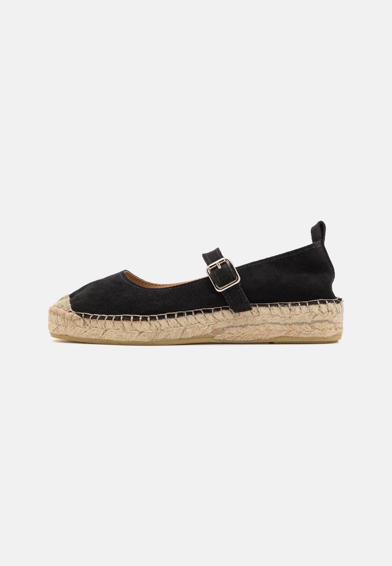 Espadrille plate noire en suède avec semelle en jute tressé et sangle à boucle réglable sur un fond clair.