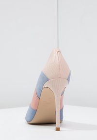 Flerfärgad högklackad sko med spetsig tå. Ovandelen har ljusrosa, blå och persikofärgade texturer; stilettklack; slät yta.