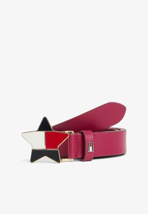 Rotolo di cintura in pelle rossa con fibbia a forma di stella divisa in sezioni nere, bianche e rosse, e un piccolo logo rettangolare sull’asola.