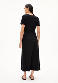 Schwarzes Midi-Kleid mit kurzen Ärmeln und lockerer Passform sowie rundem Ausschnitt. Glattes Material und schlichtes Design ohne sichtbare Muster oder Akzente.