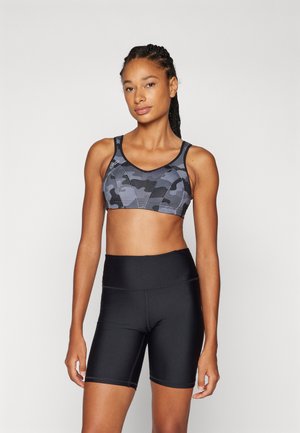 Svart sportsbh med grå camouflage mønster, justerbare stropper og et stilrent design, sammen med svarte shorts som når midt på låret. Glatt tekstur.