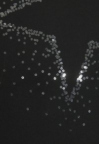 Black fabric with scattered silver sequins creating a decorative pattern. Material appears smooth with slight texture and sheen from sequins.