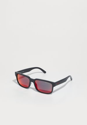 Óculos de sol pretos com grandes armações retangulares e lentes em degradê vermelho. As hastes texturizadas apresentam detalhes em vermelho. Possuem um design leve em plástico.