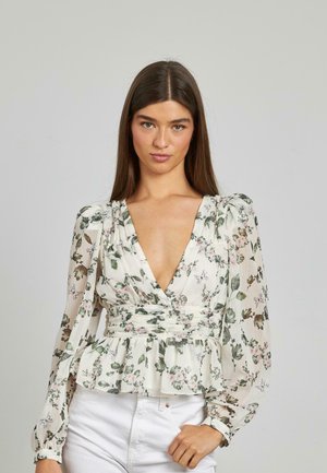 Blusa floral con un escote en V profundo, mangas largas abullonadas y cintura peplum. Tejido ligero con patrones florales verdes y rosas sobre un fondo crema.