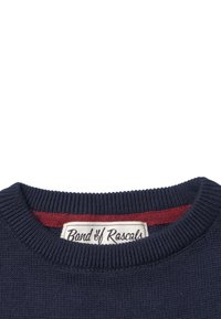 Granatowy sweter z dzianiny z prążkowanym okrągłym dekoltem i czerwonym wewnętrznym kołnierzykiem. Metka mówi "Band of Rascals." Gładka tekstura, swobodny design.