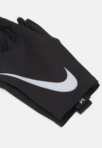 Black athletic gloves with a smooth texture, featuring a prominent gray Nike tick logo and a tag labeled "M" for size.