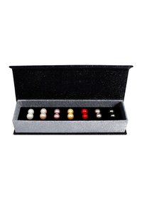 Boîte à bijoux avec un intérieur en velours noir ; contient huit perles ressemblant à des perles en blanc, rose, jaune, rouge et gris foncé, présentées dans une boîte argentée scintillante.