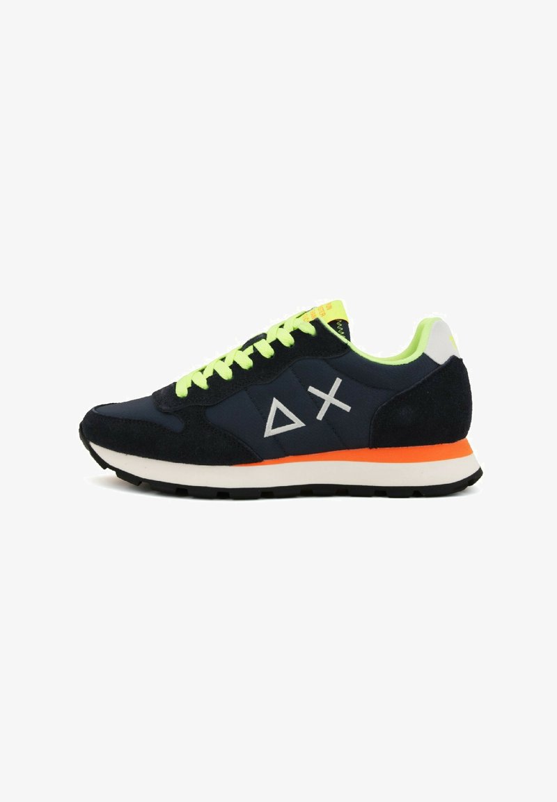 Sneaker in suede blu navy con lacci verde neon, dettagli bianchi, suola arancione e design geometrico del logo sul lato. Silhouette low-profile.