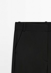 Pantalon noir en tissu lisse, avec une taille plate, des passants de ceinture et des poches latérales. Design ajusté avec des lignes épurées et un minimum de détails.