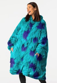 Felpa over-size in teal e viola, caratterizzata da una textura simile alla pelliccia, maniche lunghe e tasche frontali. I motivi sono irregolari e vivaci.