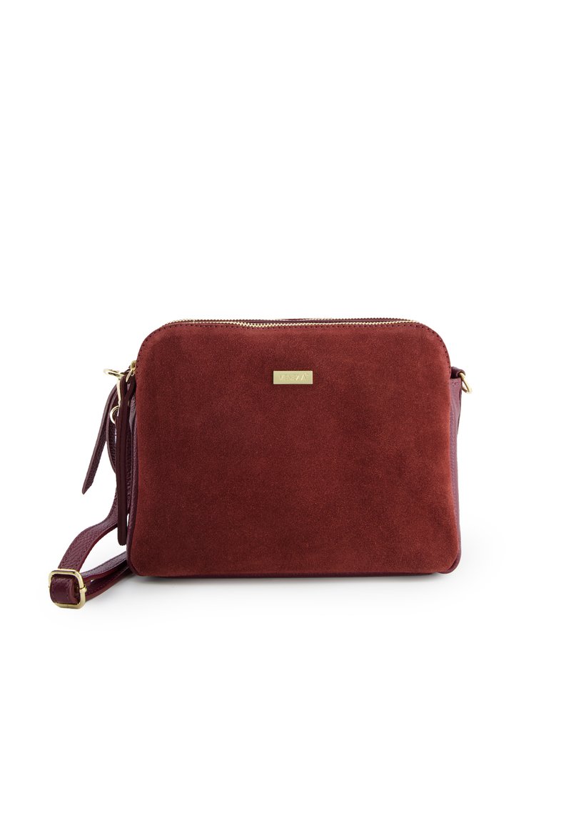 Burgundy suede crossbody bag with a smooth texture, gold zipper, and metallic brand plate; features an adjustable strap.