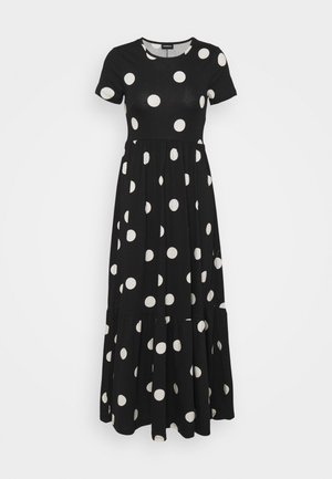 Robe longue noire à manches courtes avec de grands pois blancs et une taille froncée, présentant un ourlet à volants.