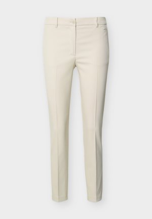 Pantalon beige ajusté pour femme avec passants de ceinture, fermeture à bouton à l'avant et plis marqués, sur fond blanc.
