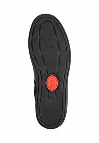 Semelle de chaussure en caoutchouc noir avec un motif de grip texturé, un centre légèrement surélevé et un accent de confort circulaire rouge dans la zone du talon.