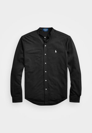 Svart skjorta med knappar, nedfällbar krage, långa ärmar och en liten broderad logotyp på vänster bröst. Tillverkad av bomullstyg.