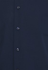 Marineblaue Hemd mit glattem Stofftextur, Knopfverschluss vorne mit schwarzen Knöpfen und maßgeschneidertem Kragen. Klassisches Design ohne Muster.