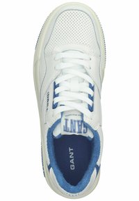 Weiße Ledersneaker mit blauen Akzenten, perforiertem Obermaterial, flachen weißen Schnürsenkeln und strukturiertem blauen Innenfutter. Branding auf der Zunge sichtbar.