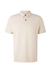 Béžová polo tričko vyrobené z měkké tkaniny, s límečkem, krátkými rukávy, knoflíkovou lištou se dvěma knoflíky a malým logem na hrudi.