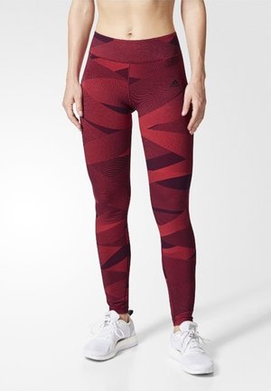 High-waisted sportleggings in het rood met donkere geometrische patronen, gemaakt van textuurstretchstof, met een strakke pasvorm en een elastische tailleband.