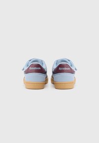 Reebok sneakers in light blue with a navy panel, featuring a burgundy heel tab and gum sole; hook-and-loop straps for secure closure.