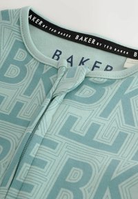 Sinine puuvillane riideese, millel on geomeetriline muster ja kontrastne must silt, millel on ka tekst "BAKER by TED BAKER" kaeluses.