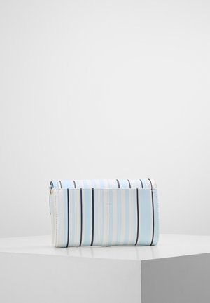 Pochette rectangulaire à rayures verticales bleu clair, blanc et noir, présentée sur un socle blanc contre un fond uni.