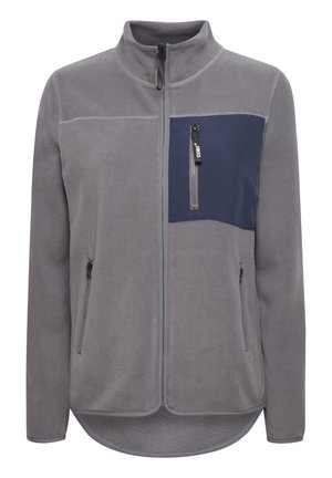 Fleecejack in grijs met een marineblauw borstpaneel. Heeft een hoge kraag, twee zijzakken met rits en een ritszak op de borst.