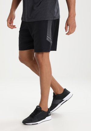 Shorts de sport noirs avec un motif graphique latéral gris, fabriqués à partir d'un tissu léger. Portés avec des chaussures de course noires à accents blancs.