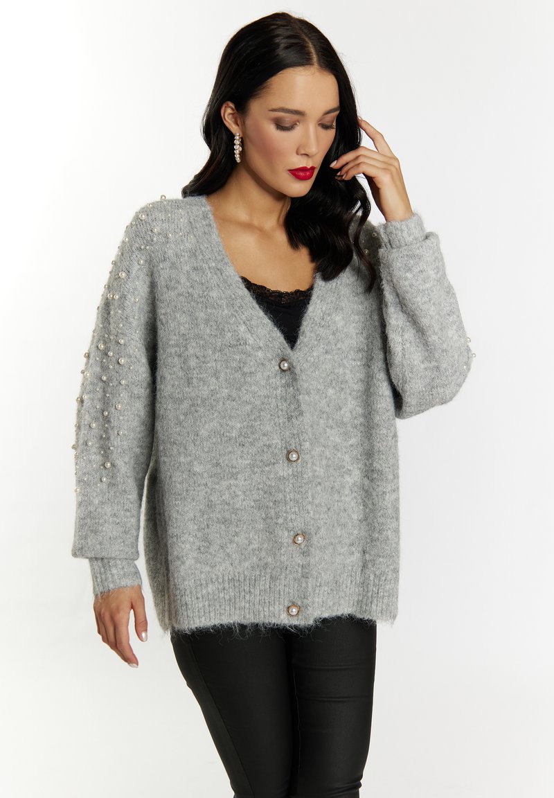 Cardigan grigio lavorato a maglia con scollatura a V profonda, grandi bottoni frontali e decorazioni in perle sulle maniche. Tessuto morbido e testurizzato.