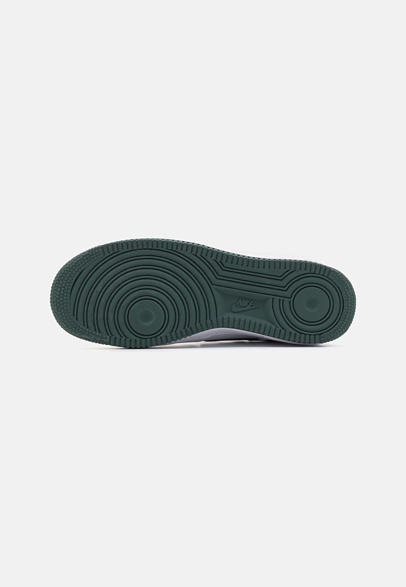 Suola di sneaker Nike in gomma verde scuro, con un motivo testurizzato caratterizzato da scanalature circolari e lineari per una migliore trazione.