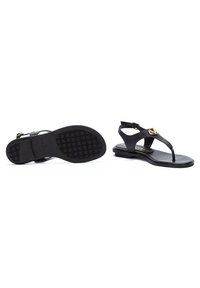Sandales en cuir noir avec un design thong, une sangle de cheville réglable, des accents dorés et une semelle en caoutchouc texturé.