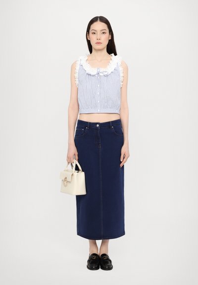 Blauwe geruite crop top met witte rimpel kraag, gecombineerd met een donkerblauwe denim midi rok. Gecombineerd met een crème handtas en zwarte instappers.