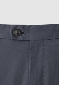 Mörkblå byxor med en slät yta, en svart knappknäppning och subtila sömnadsdetaljer vid midjan.