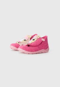 Rosa filt innersåler med et tegneserieansikt-design, rund form og teksturert gummisåle. Viktige funksjoner inkluderer rosa detaljer og øreflapper.